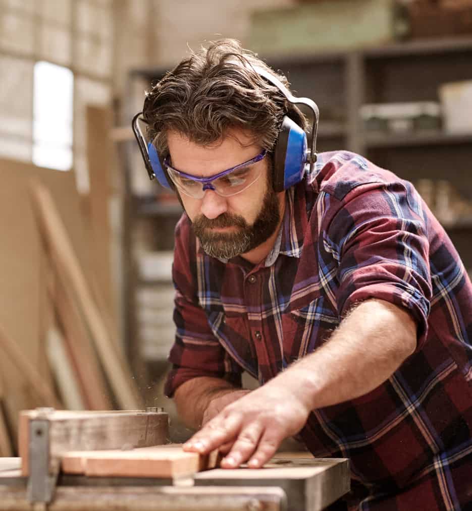 Middle age guy working in his wood working business.