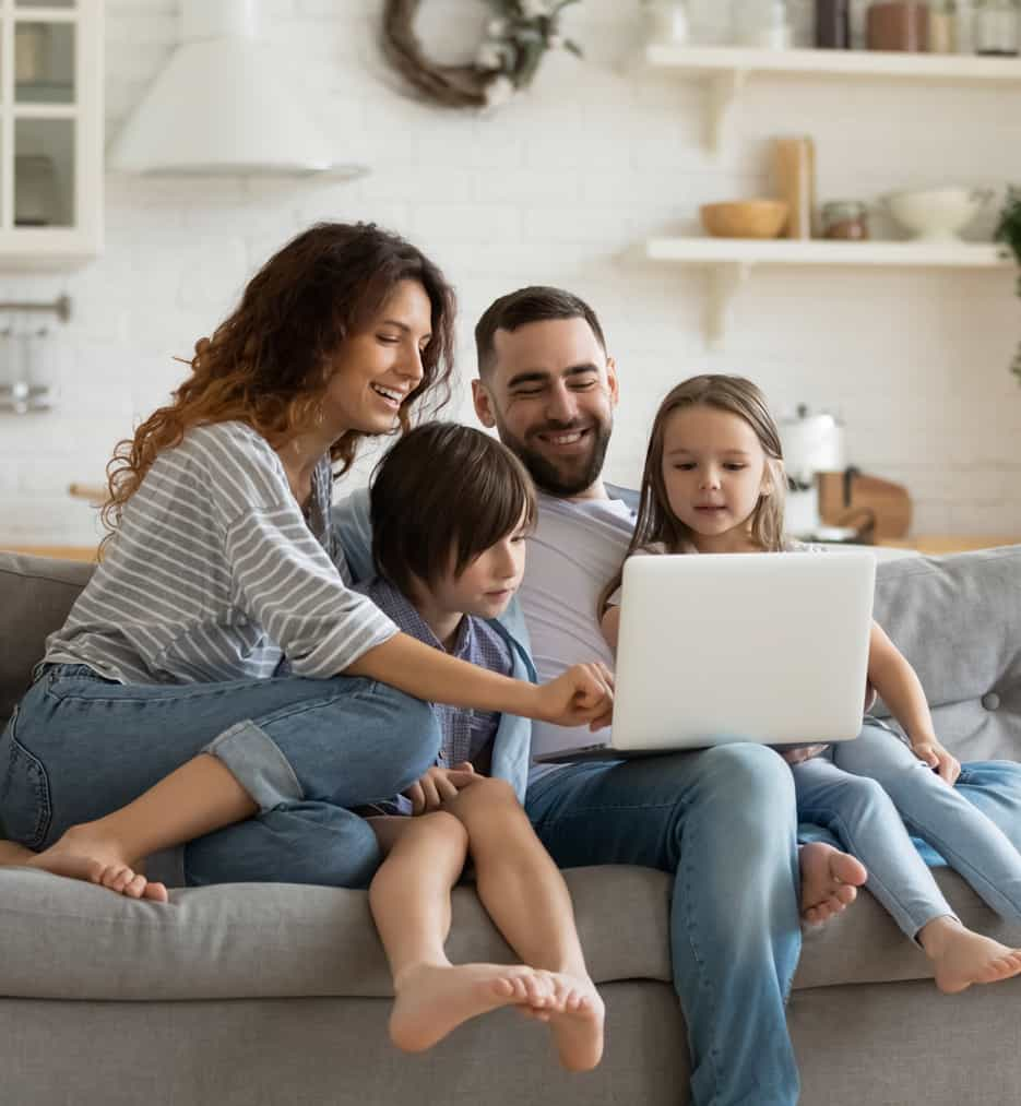 Family sitting on couch in new home.