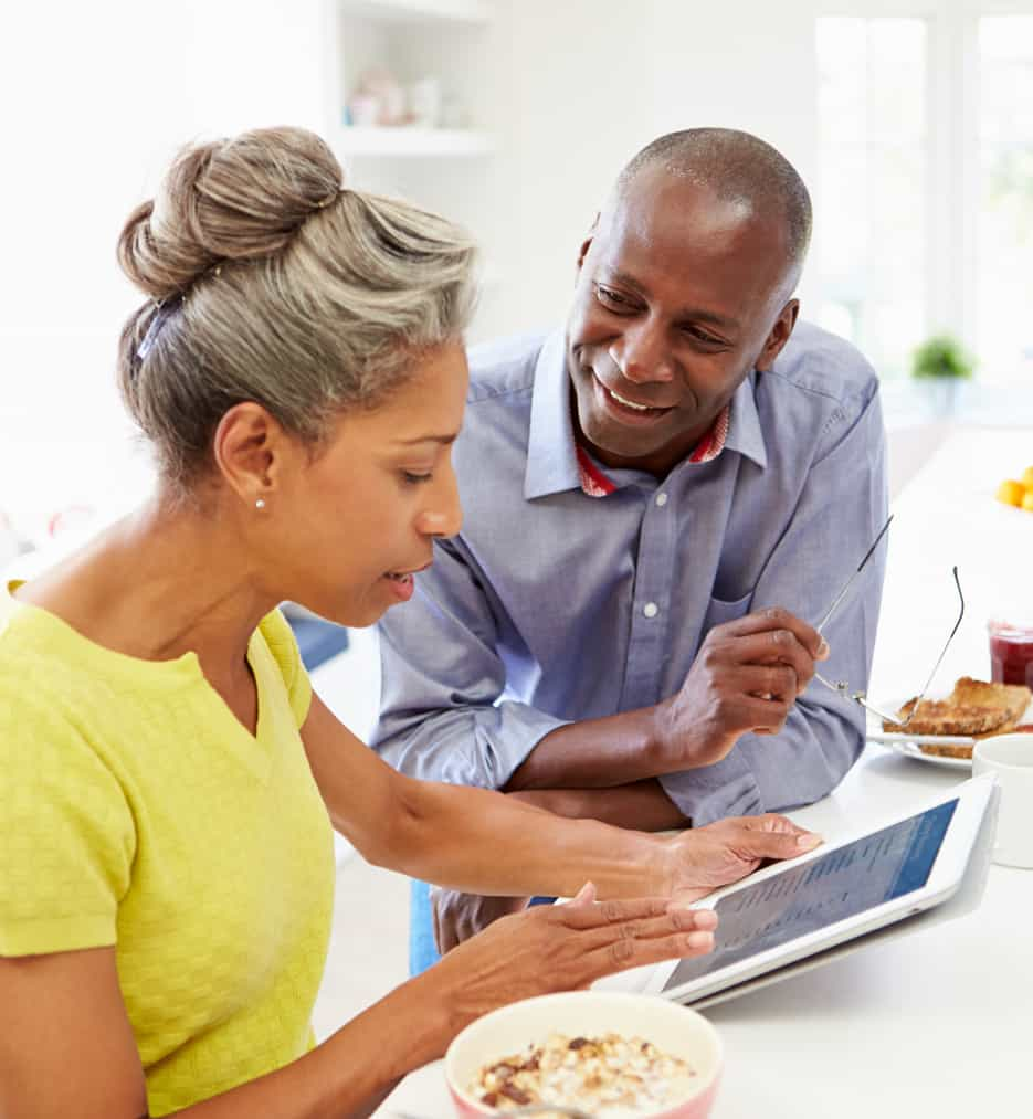 Older couple smiling in kitchen.