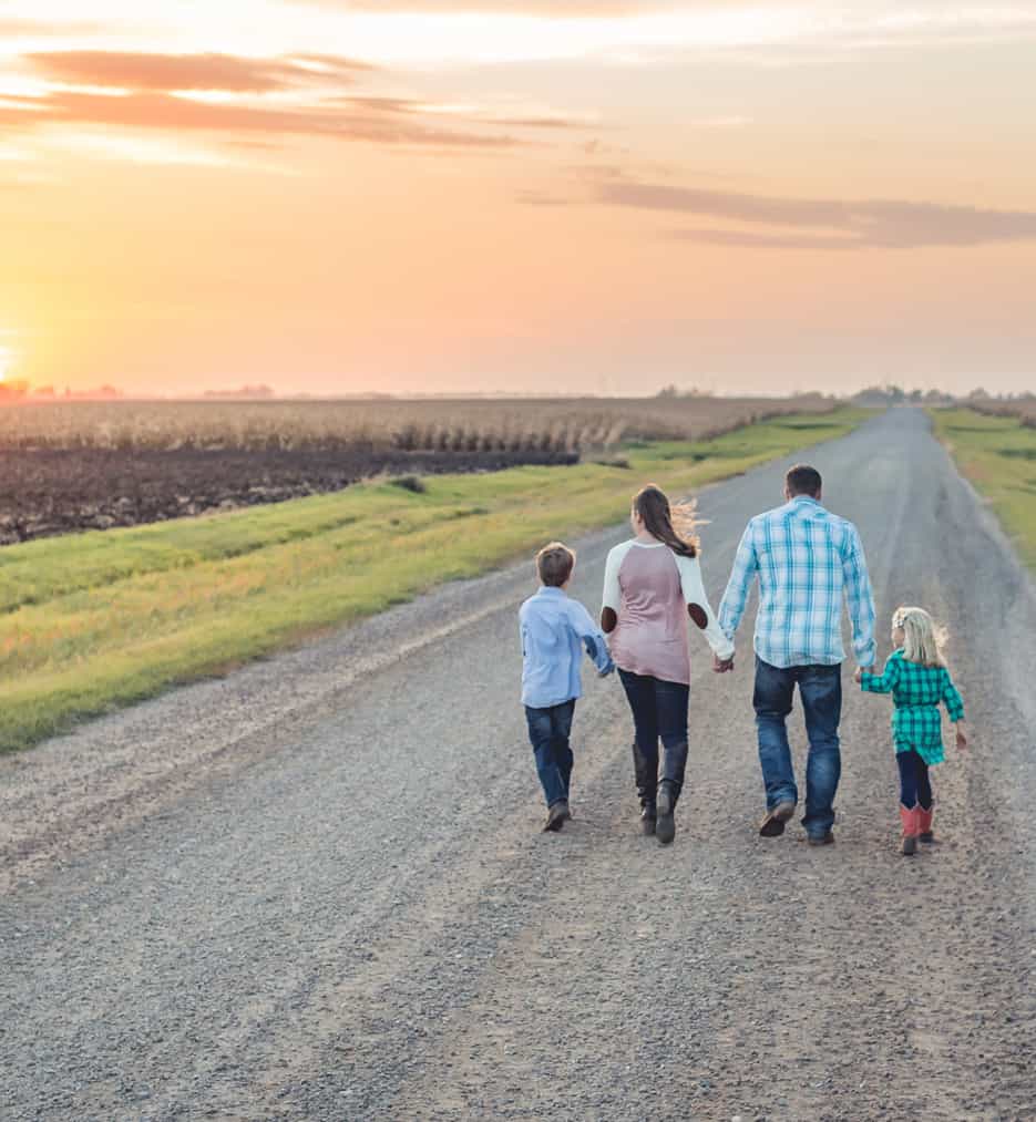 Young family walking country road.