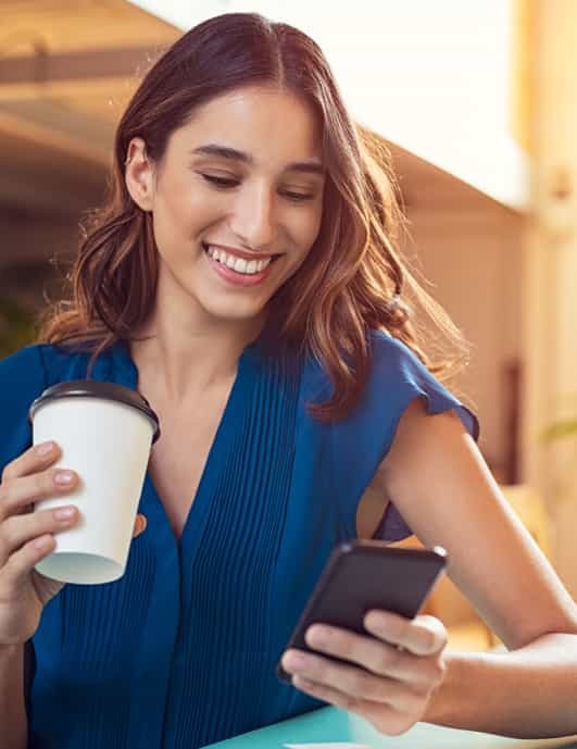 Young woman at cafe looking at phone.