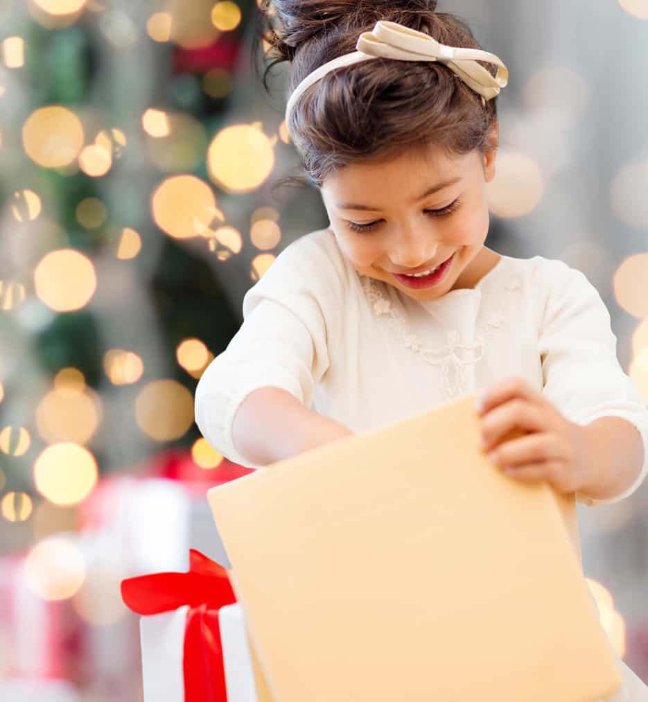 Little girl opening her packages at christmas.